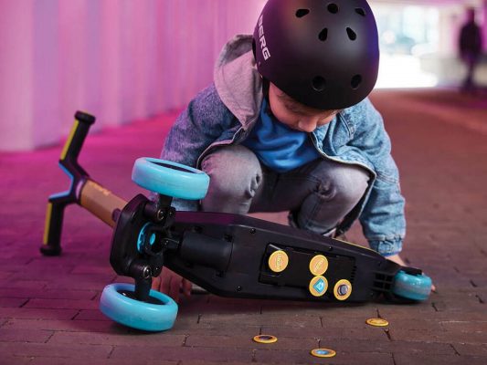 kid wearing a helmet, with a childs scooter